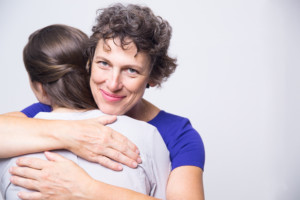 Happy senior woman embracing young adult daughter